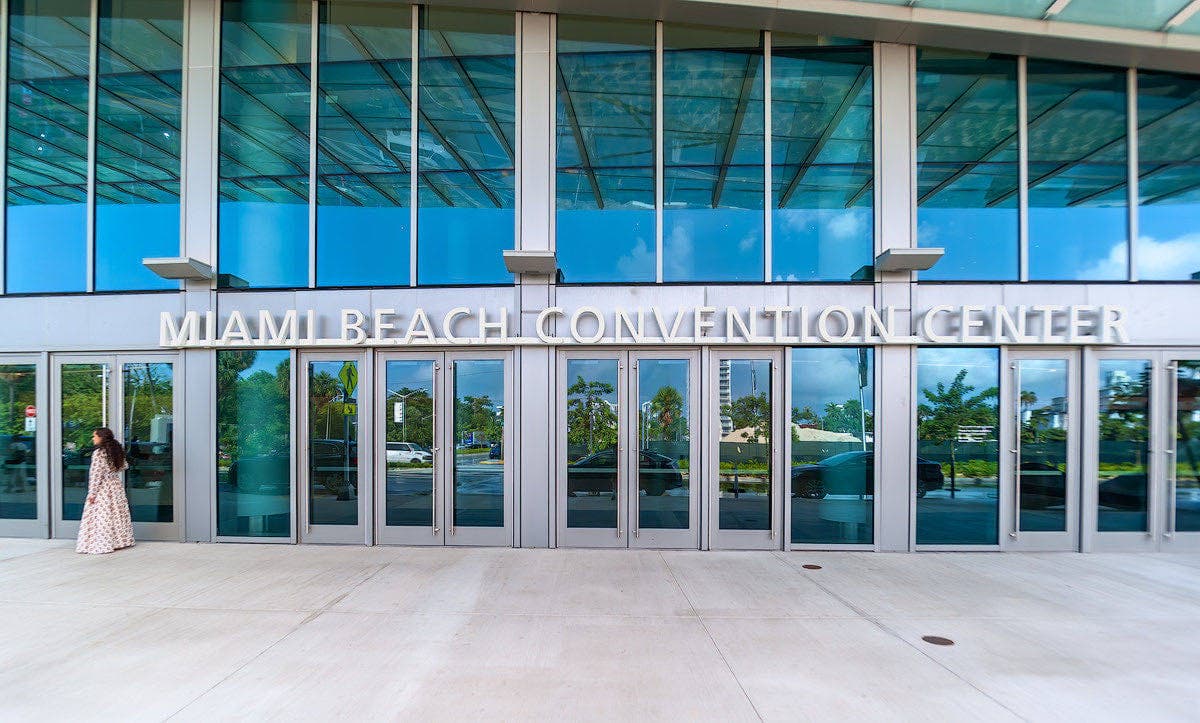 Miami Beach Convention Centerの正面入口。ガラス張りのファサードに施設名の白い文字が掲げられている