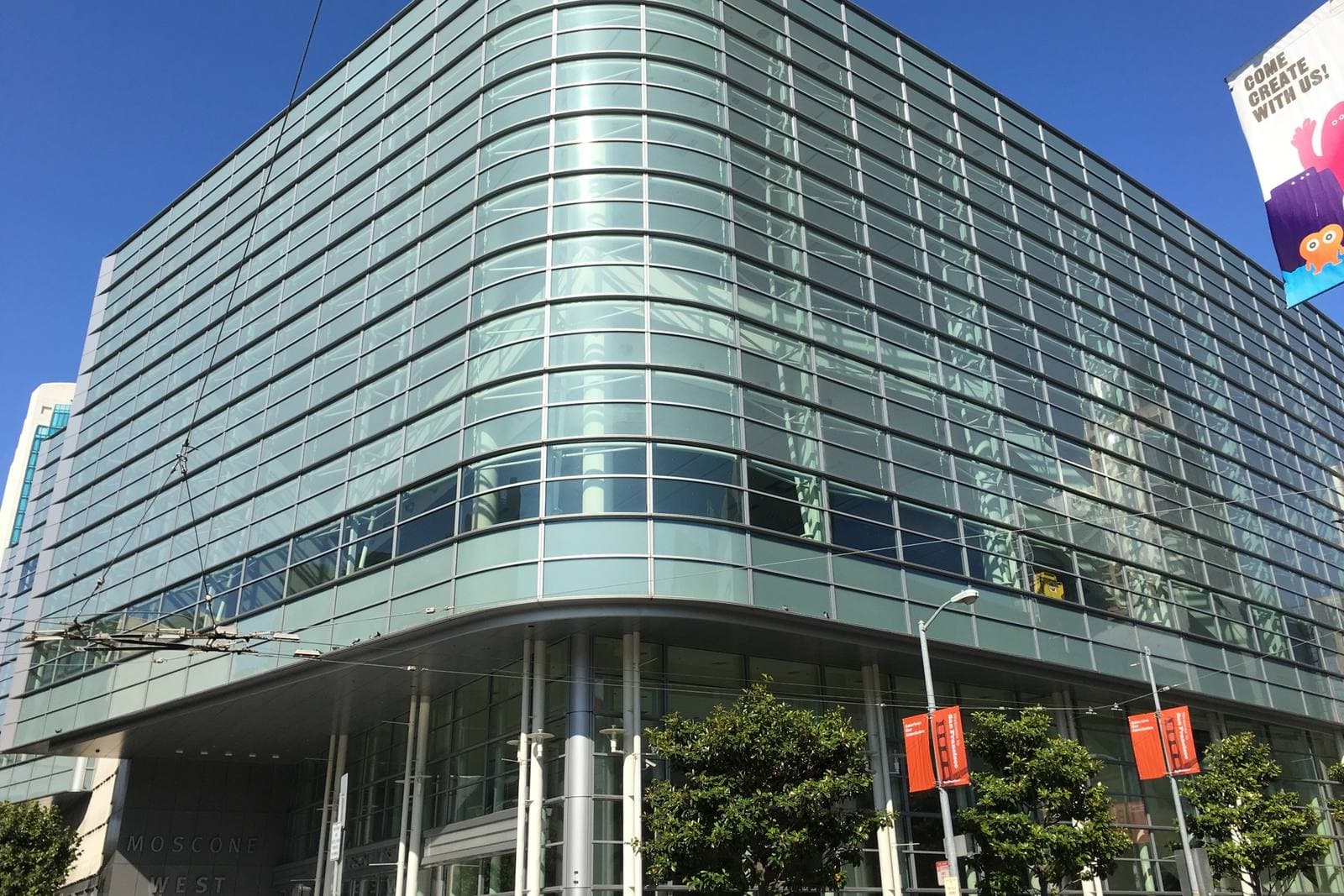 曲面のガラスに覆われたMoscone Westの外観。低層部の壁面に「MOSCONE WEST」の表示が見える