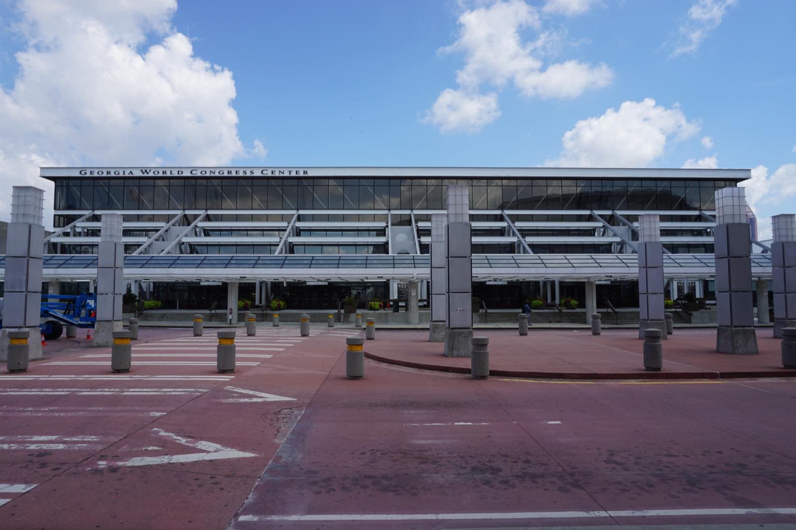 青空の下のGeorgia World Congress Centerの正面外観。ガラス張りのファサードに施設名が掲げられている