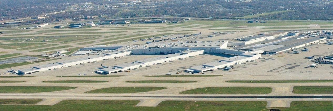 ルイビル空港の航空写真。滑走路の奥に、UPSワールドポートの細長い仕分け施設と駐機した貨物機が広がっている