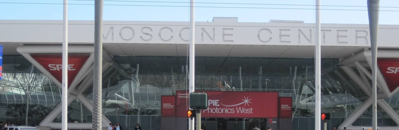 Howard Street越しに見たモスコーニ・センターの入口。ひさしの上に「MOSCONE CENTER」の切り文字が並び、その下にSPIE Photonics Westの赤いバナーと出展社登録の表示が掲げられている