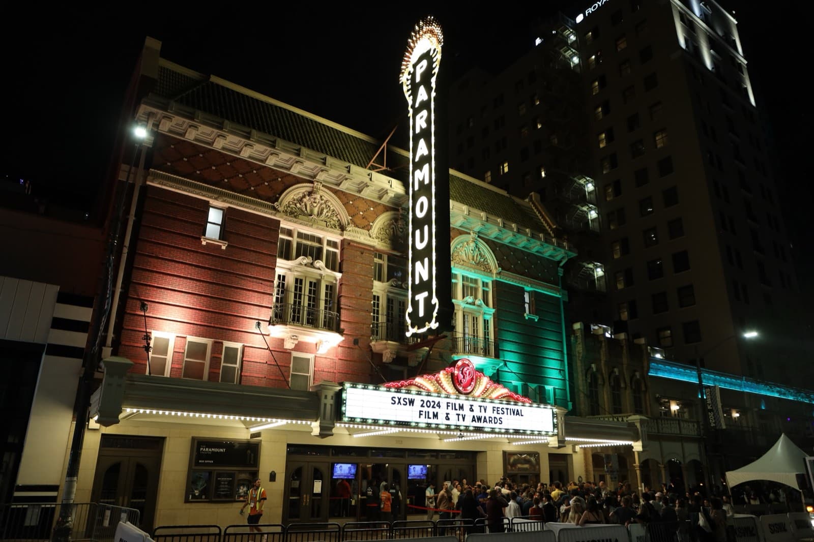 夜のオースティン。SXSW 2024の上映を告げるマーキーが灯るParamount Theatreの外観と、入口前の人だかり