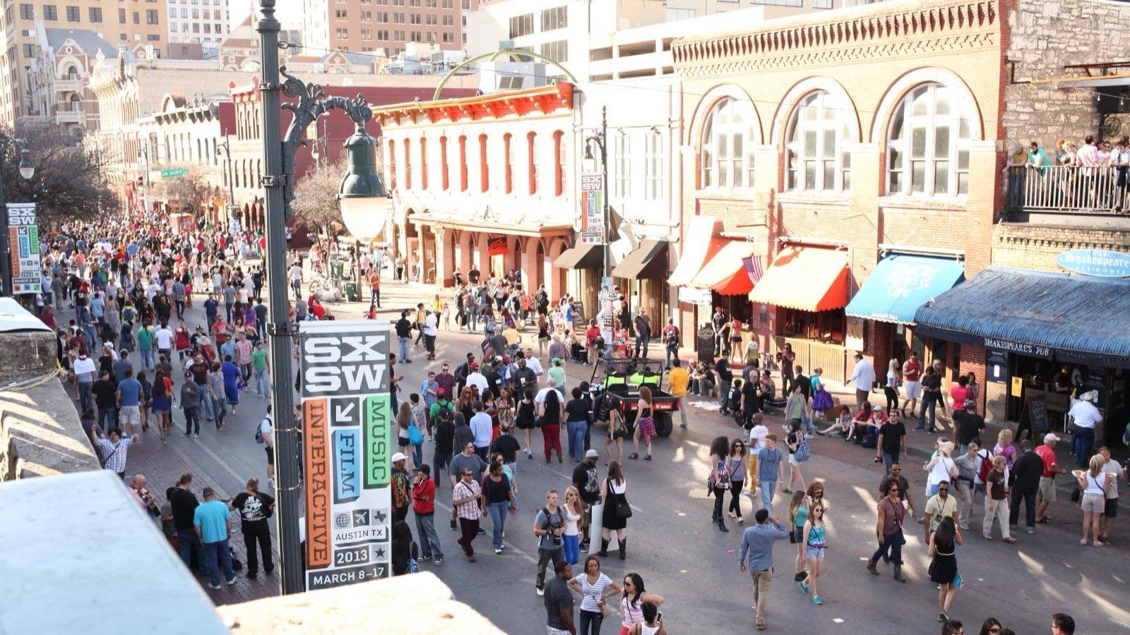 車両が入らず歩行者で埋まったオースティンの6th Streetを見下ろした写真。街灯にSXSWの公式バナーが掛かっている